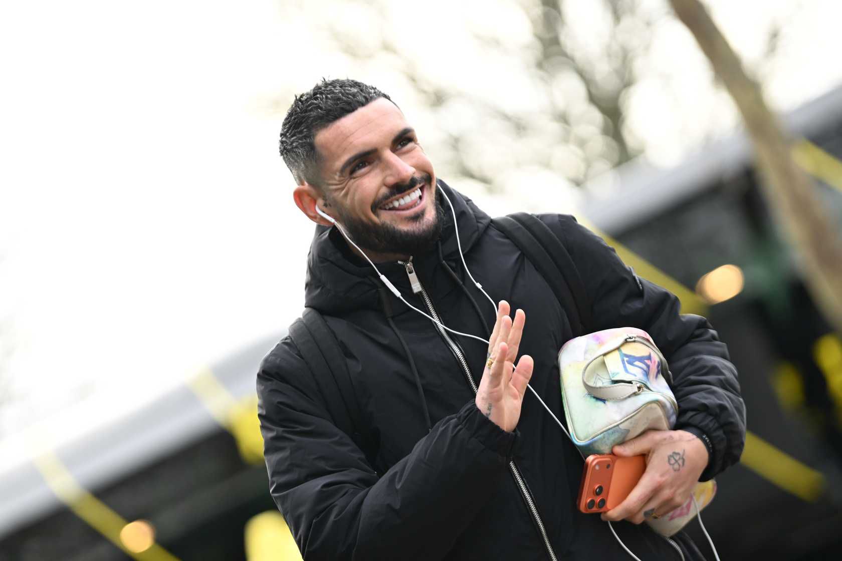 Rémy Cabella souriant en arrivant au stade avec ses écouteurs