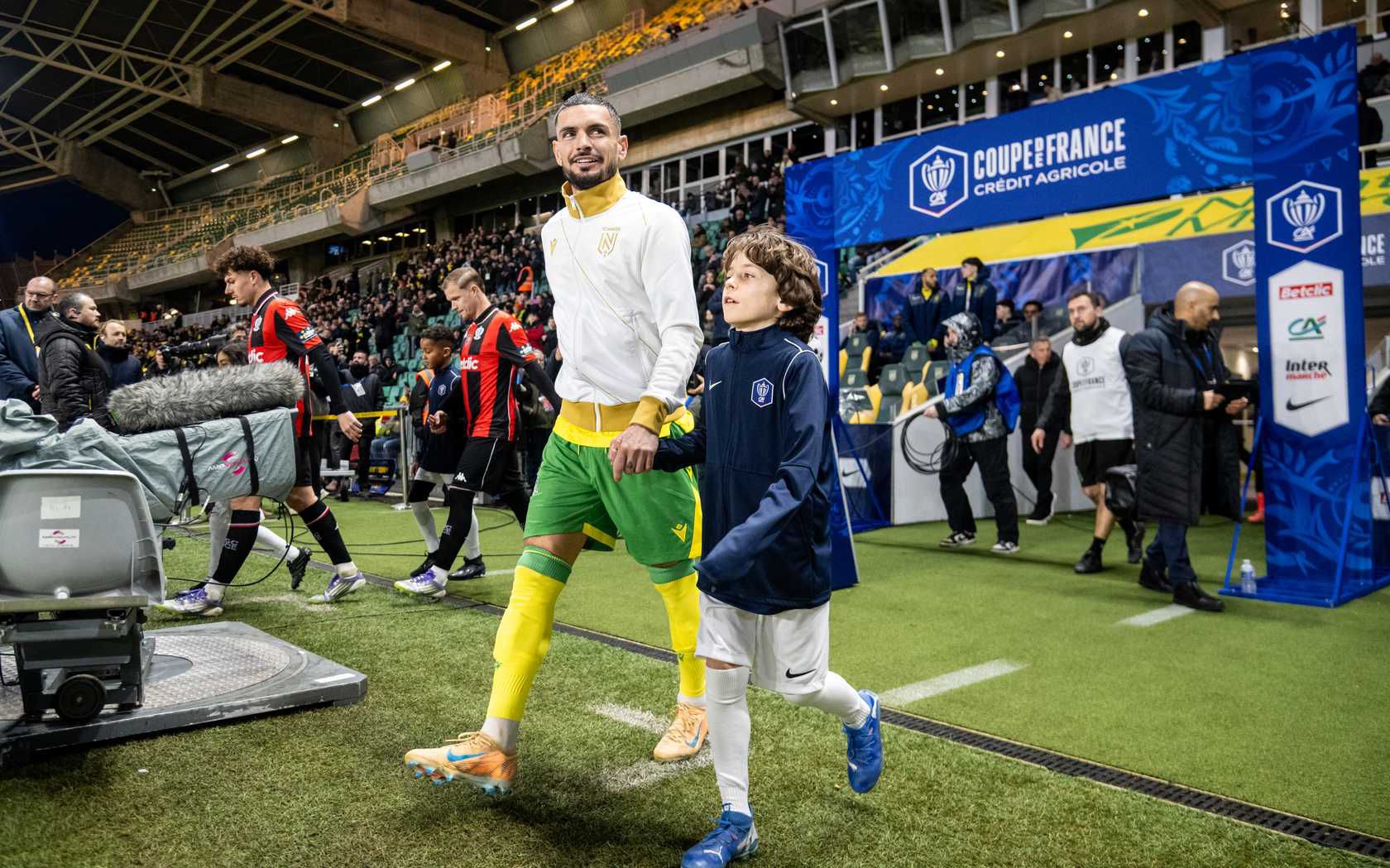 Rémy Cabella entre sur le terrain avec un enfant en Coupe de France